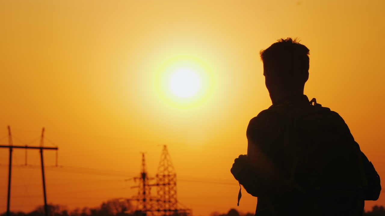 un hombre con una mochila detrás de él se alza contra el fondo del paisaje urbano en la distancia