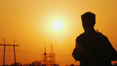 a man with a backpack behind him stands against the background of the urban landscape in the distanc