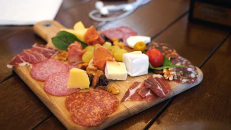 cheese plate with meat, nuts, fruits, and vegetables at a wine tasting event