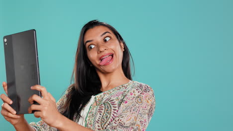 narcissistic woman using tablet to take selfies from all angles