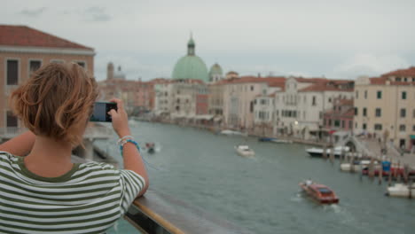 teenager photographing the grand canal and san simeone piccolo