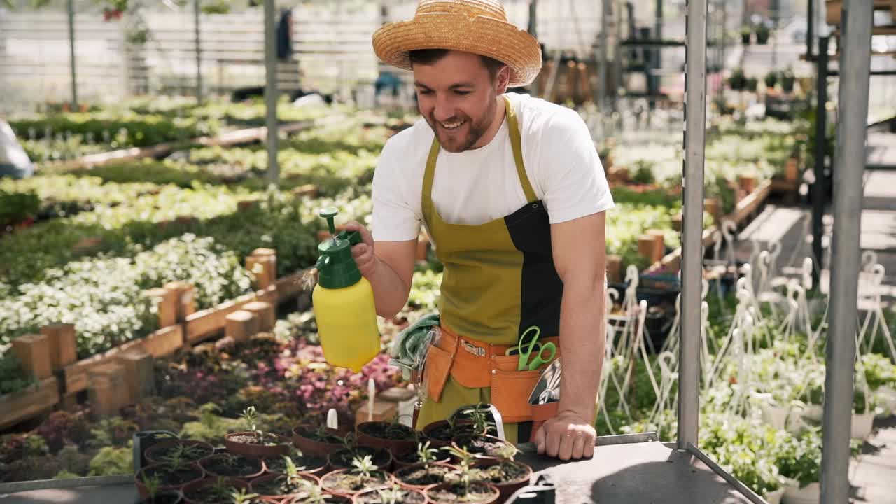 jardinero masculino regando plantas con un rociador