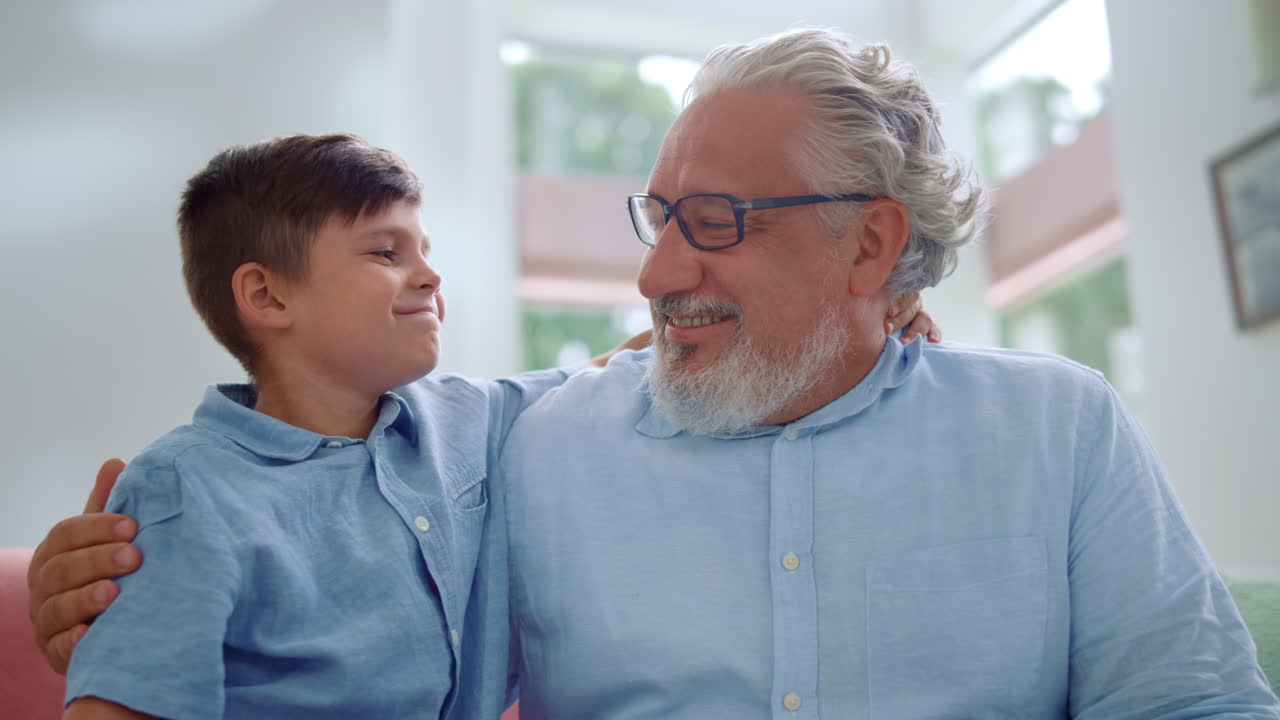 abuelo y nieto felices abrazados juntos en la sala de estar