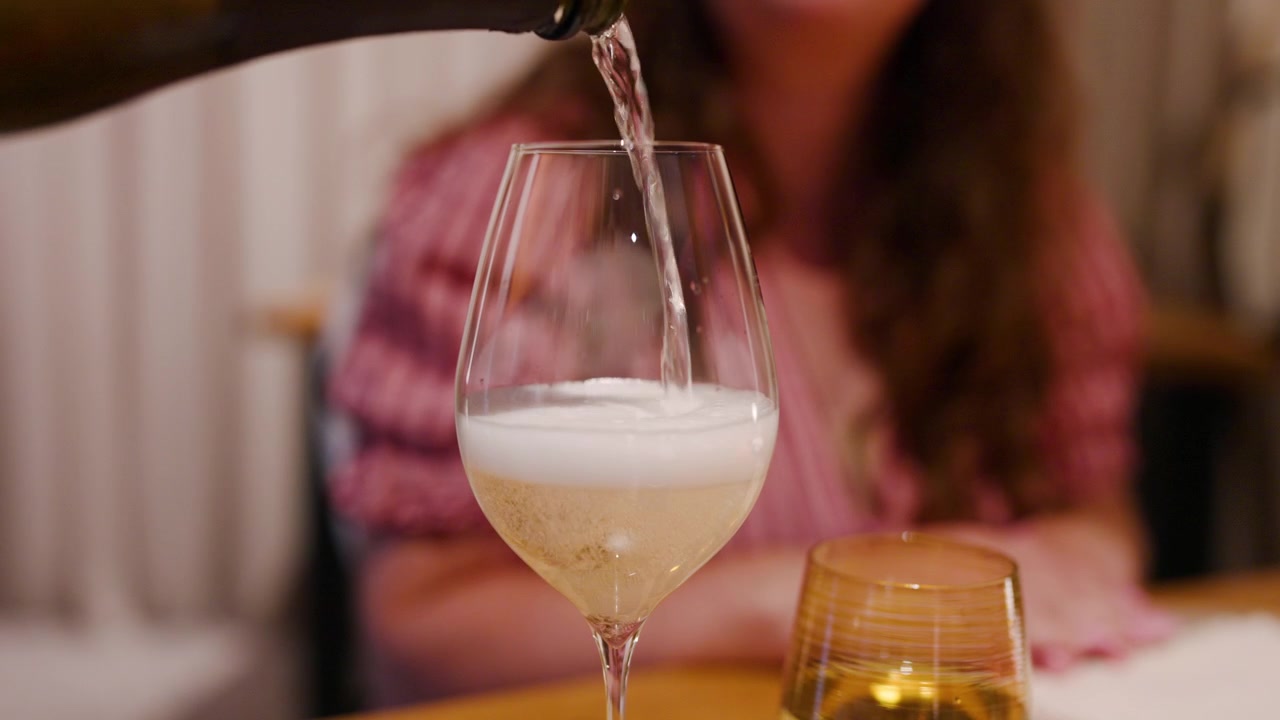Vino versato in un bicchiere durante un'esperienza culinaria raffinata in un ristorante elegante. Primo piano