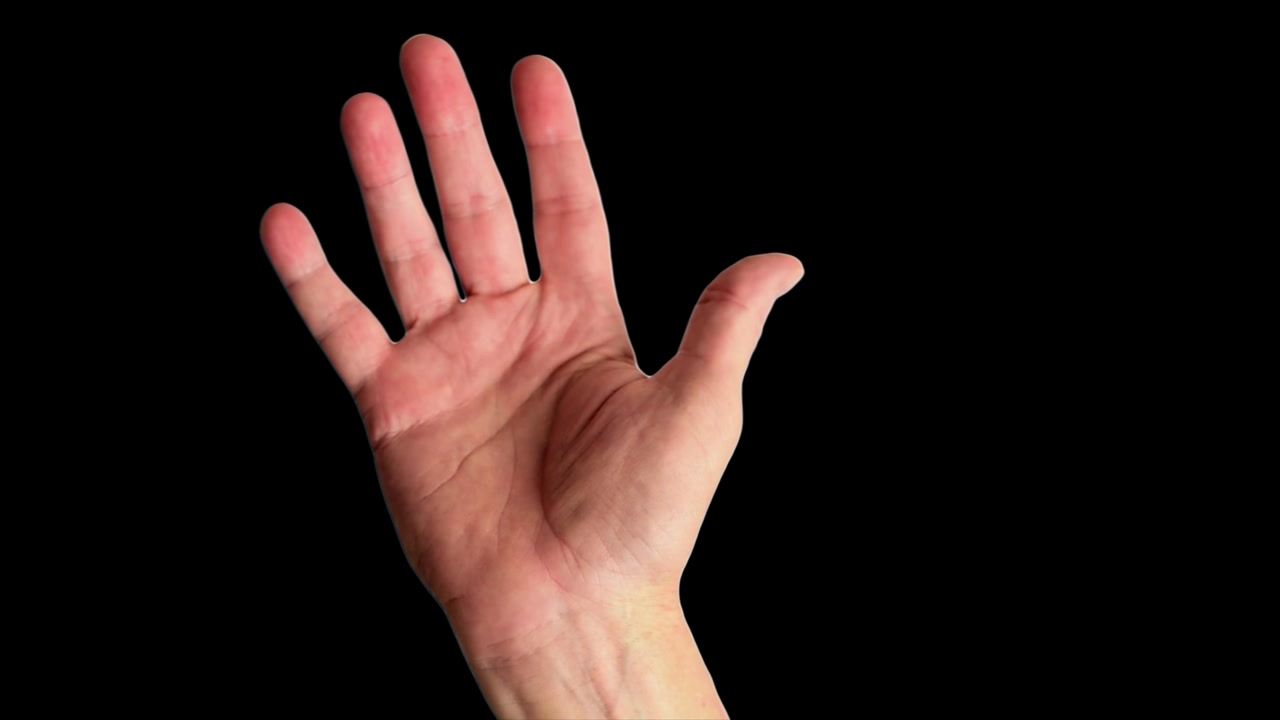 Primo piano di una mano maschile che fa un gesto allegro di saluto, su uno sfondo nero semplice