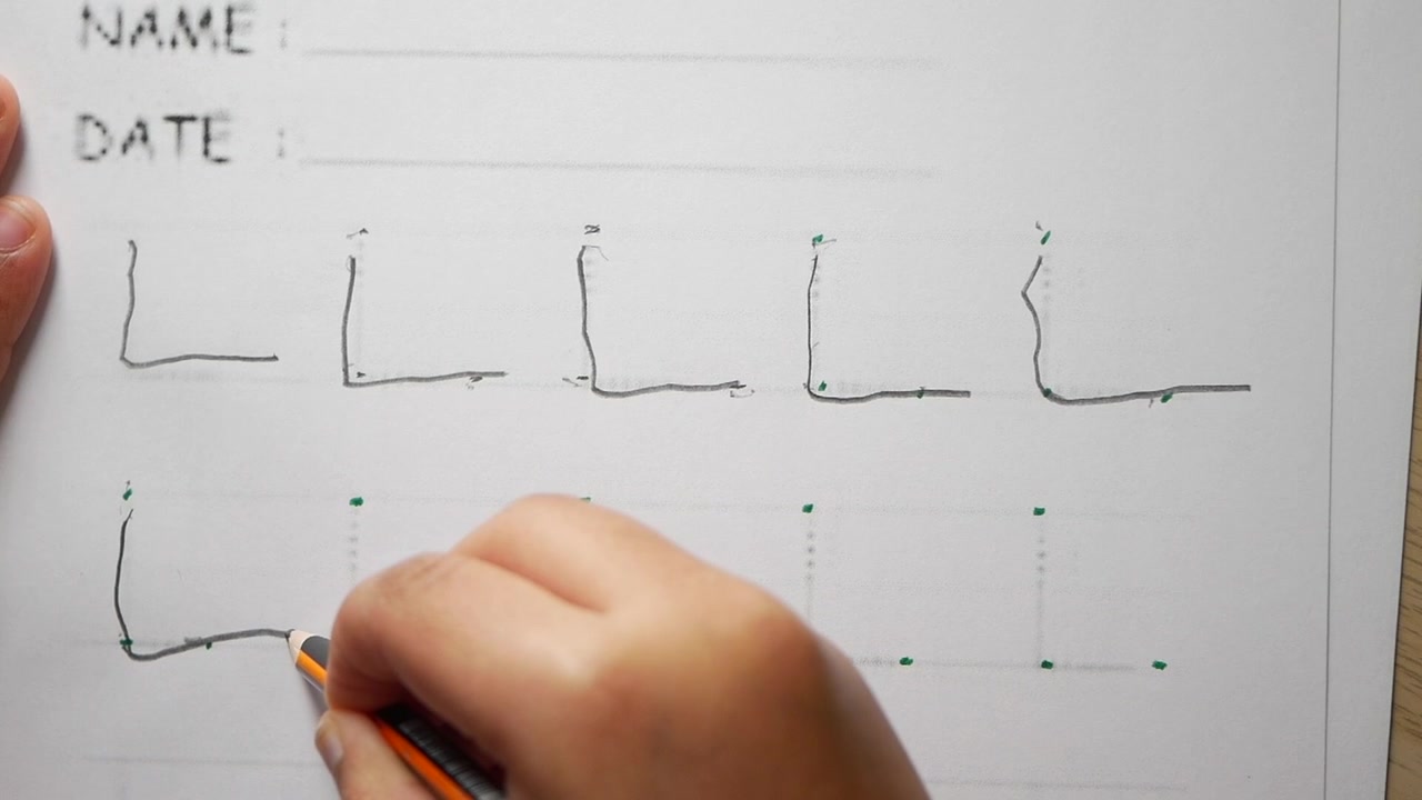 Child's Hand Tracing the Letter L on a Learning Worksheet