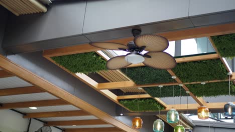 modern ceiling fan and hanging lights in a wooden ceiling