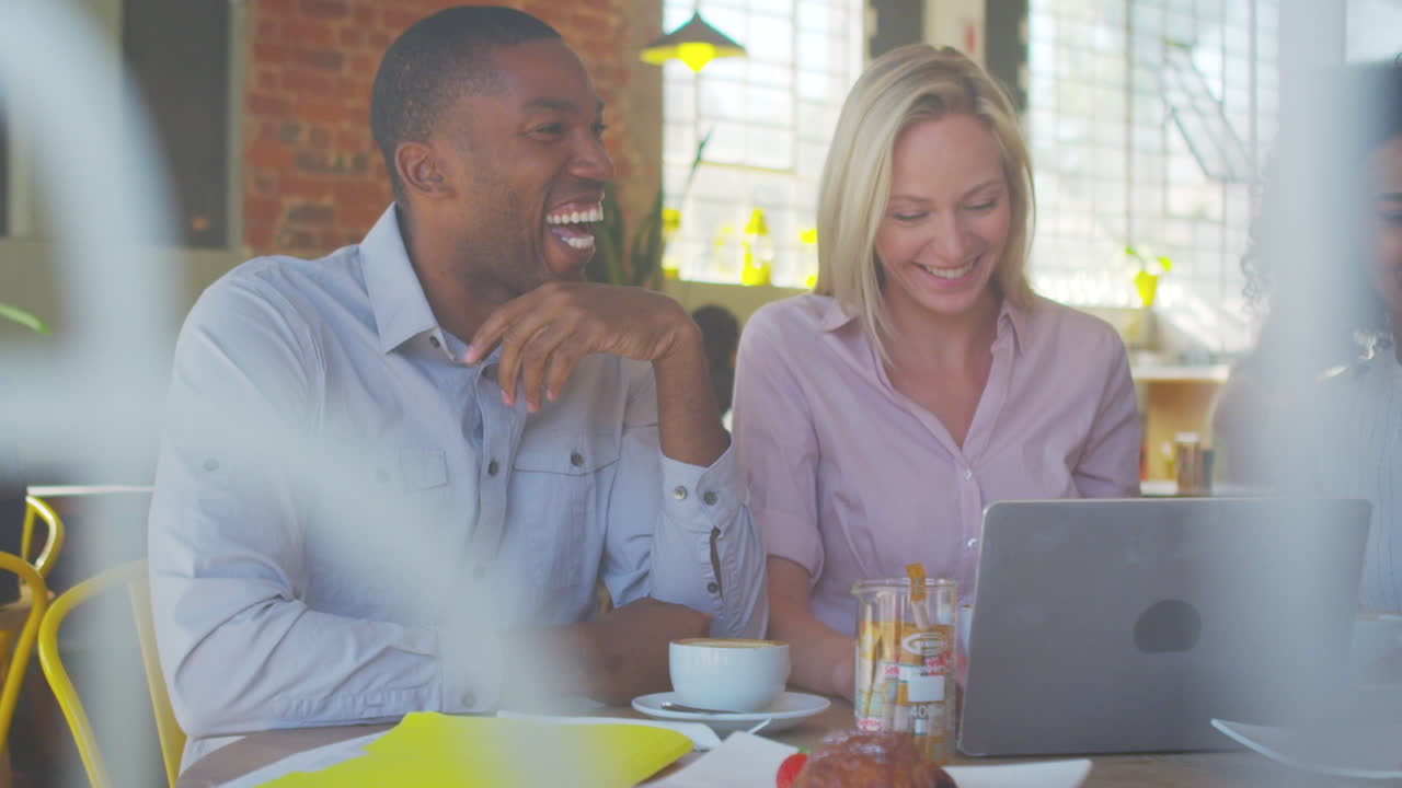 Businesspeople Meeting In Coffee Shop Shot Through Window