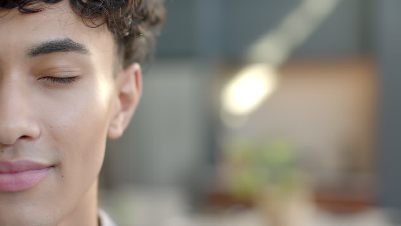 Smiling man with eyes closed, enjoying peaceful moment at home, copy space