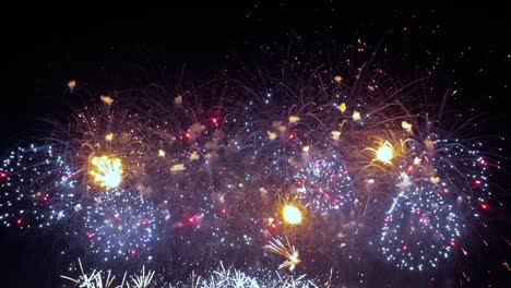 coloridos fuegos artificiales explotando en el cielo nocturno. celebraciones y eventos en colores brillantes.