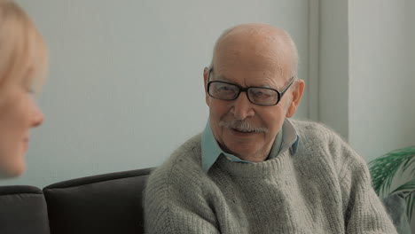 portrait of elderly man talking with young caring nurse