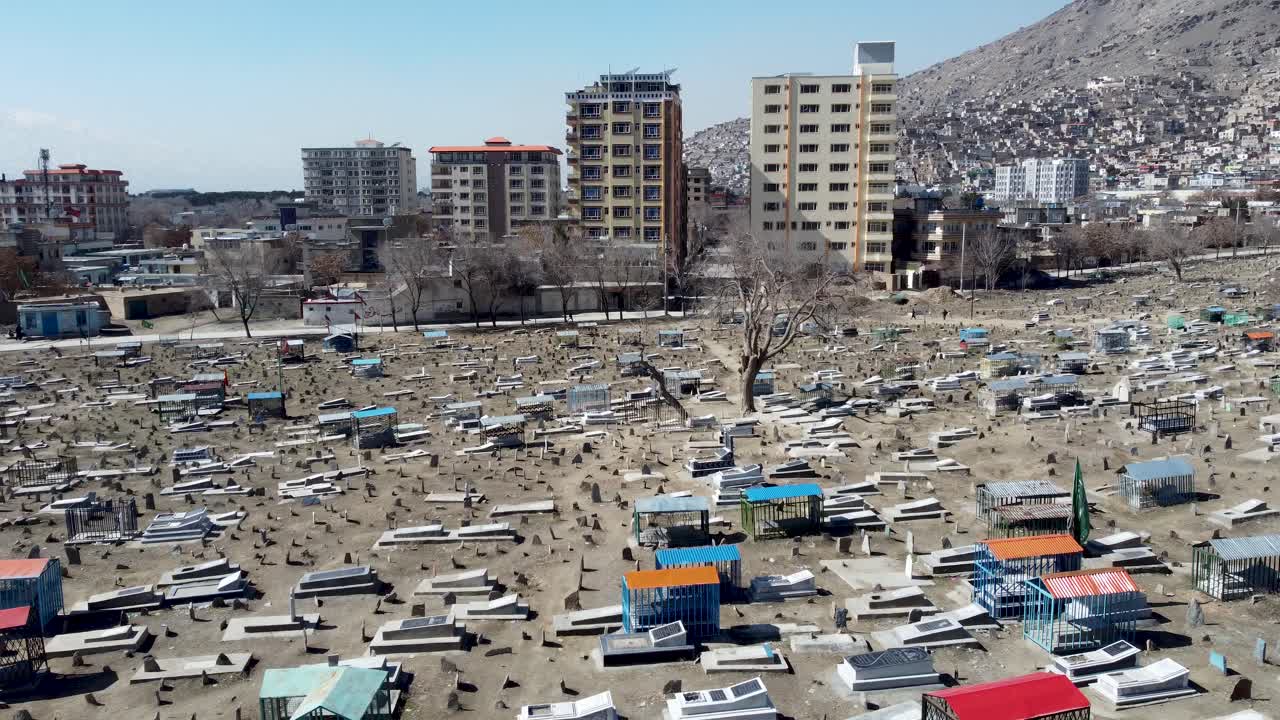 Kabul, Afghanistan. Drone Shot of Cemetery at Sakhi Shrine Mosque, Graves, Neighborhood Buildings, American war memorial
