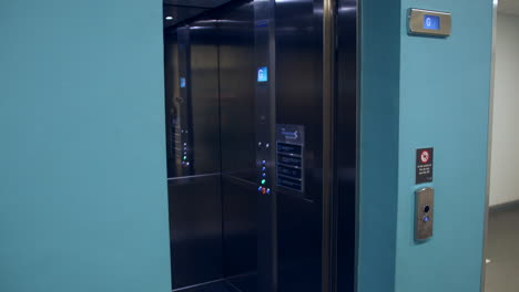 a woman pressing an elevator call button and doors opening