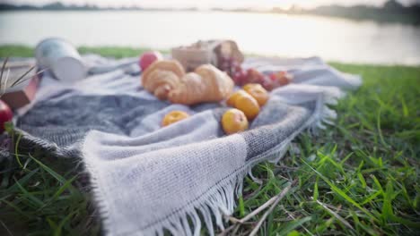 Picknickhintergrund-Mit-äpfeln,-Trauben,-Mandarinen-Und-Croissants-Am-Strand