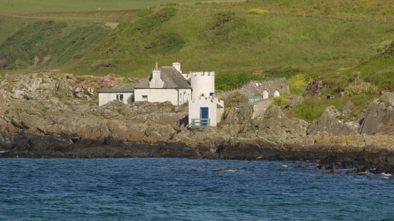 long shot of port Logan fish pond buildings from port Logan beach.