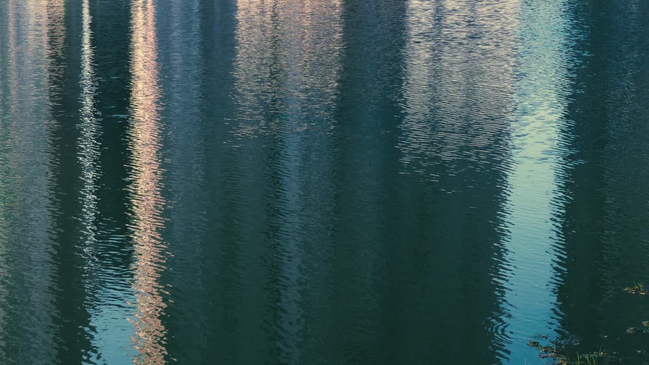 Building reflection in water ripple at lake background