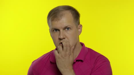 portrait of young caucasian man posing in pink t-shirt. worried handsome guy shocked, afraid, scared