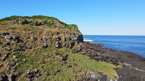 rocas volcánicas y acantilados de basalto de la isla cook en verano - área marina protegida en el océano pacífico sur, nsw, australia