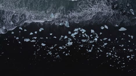 Aerial-top-down-over-waves-breaking-on-black-sandy-lagoon-at-Diamond-beach,-Iceland