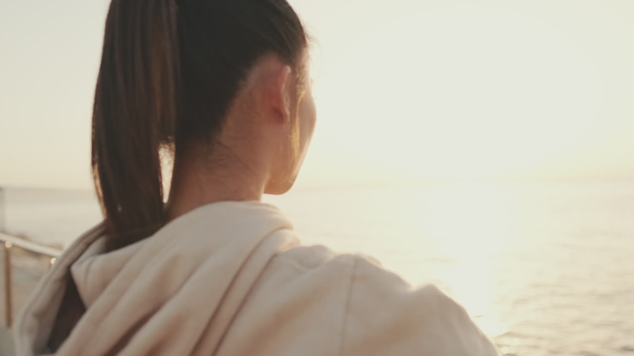 夕焼け時の海辺にいる女性