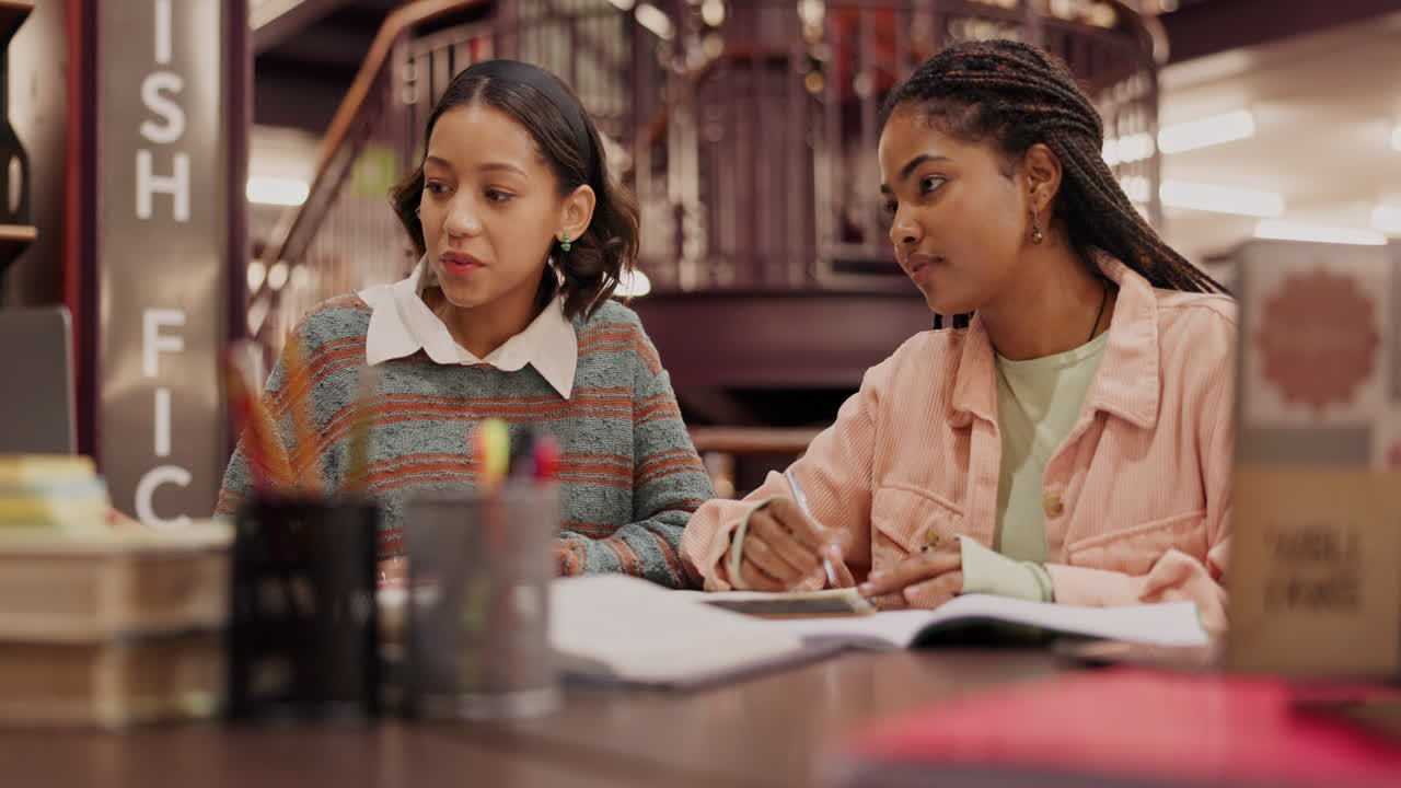 Two students studying together in the library