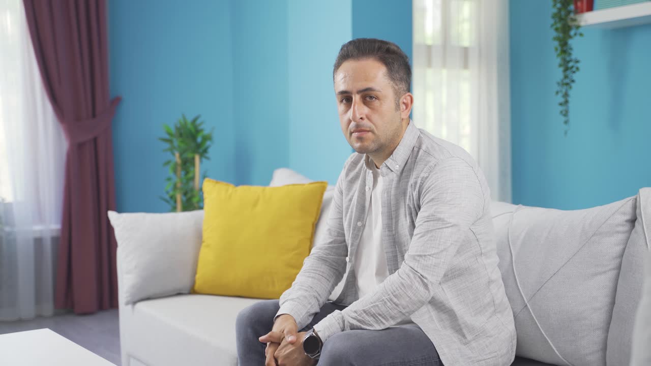 Uomo che guarda la telecamera con espressione spenta
