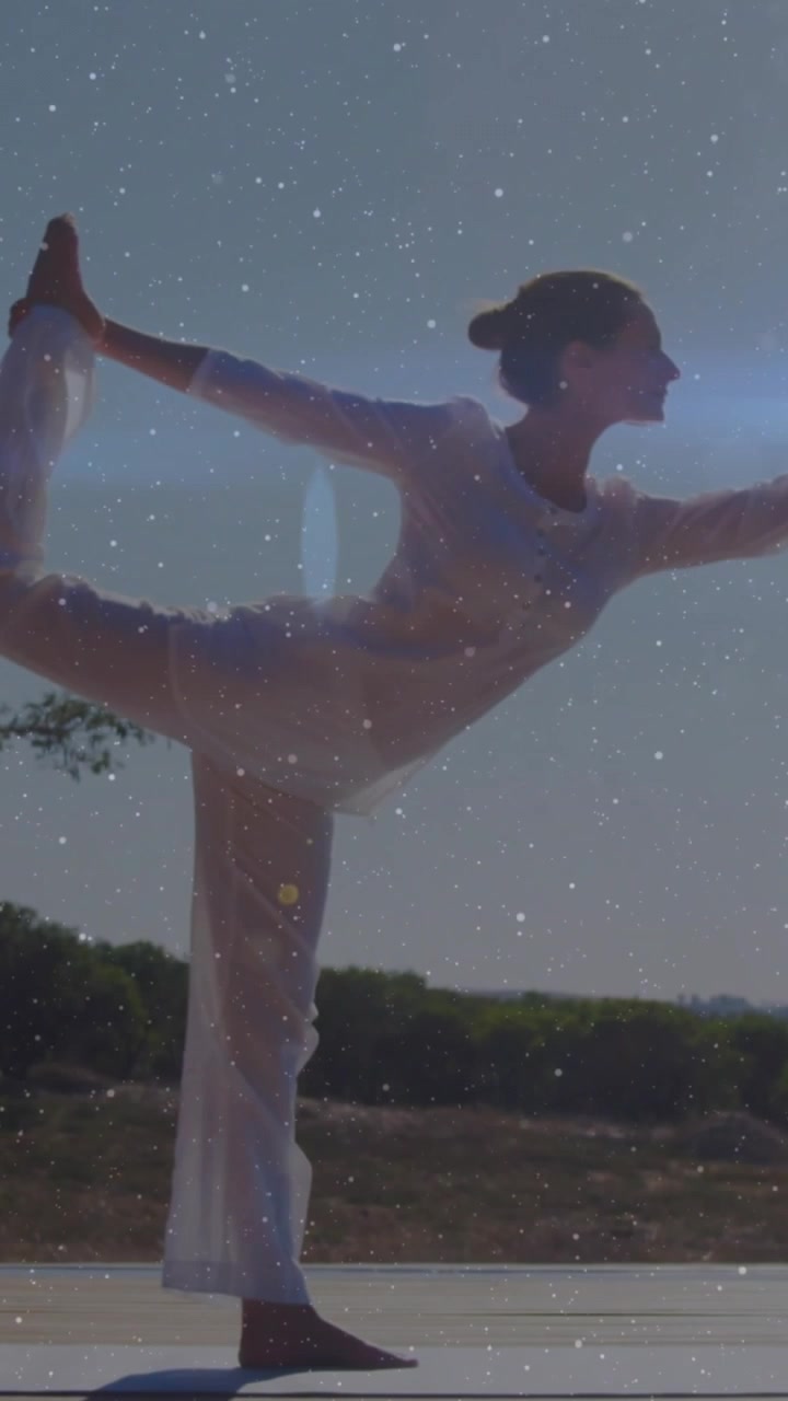 Video verticale: Donna che si muove, mantiene una posizione yoga, in equilibrio con sovrapposizione di stelle e un bagliore orizzontale.