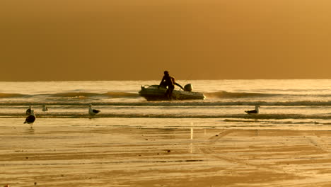 silhouettes of fishermen in a small boat at sunset