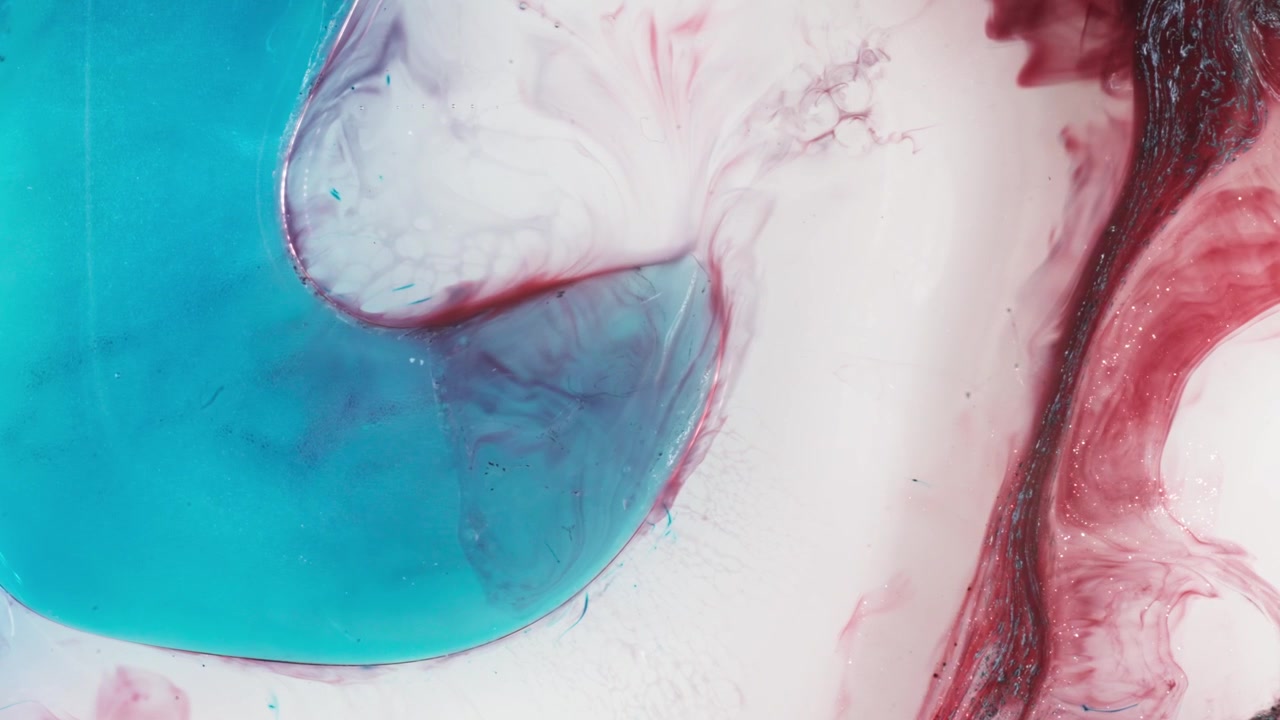 Close-up macro de tinta alcoólica girando em líquido, criando padrões etéreos em rosa e azul profundo com uma estética cinematográfica e onírica para fundos artísticos.