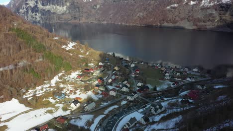 vista aérea distante del pueblo de undredal junto al fiordo de aurlands - vista aérea del soleado invierno durante el amanecer