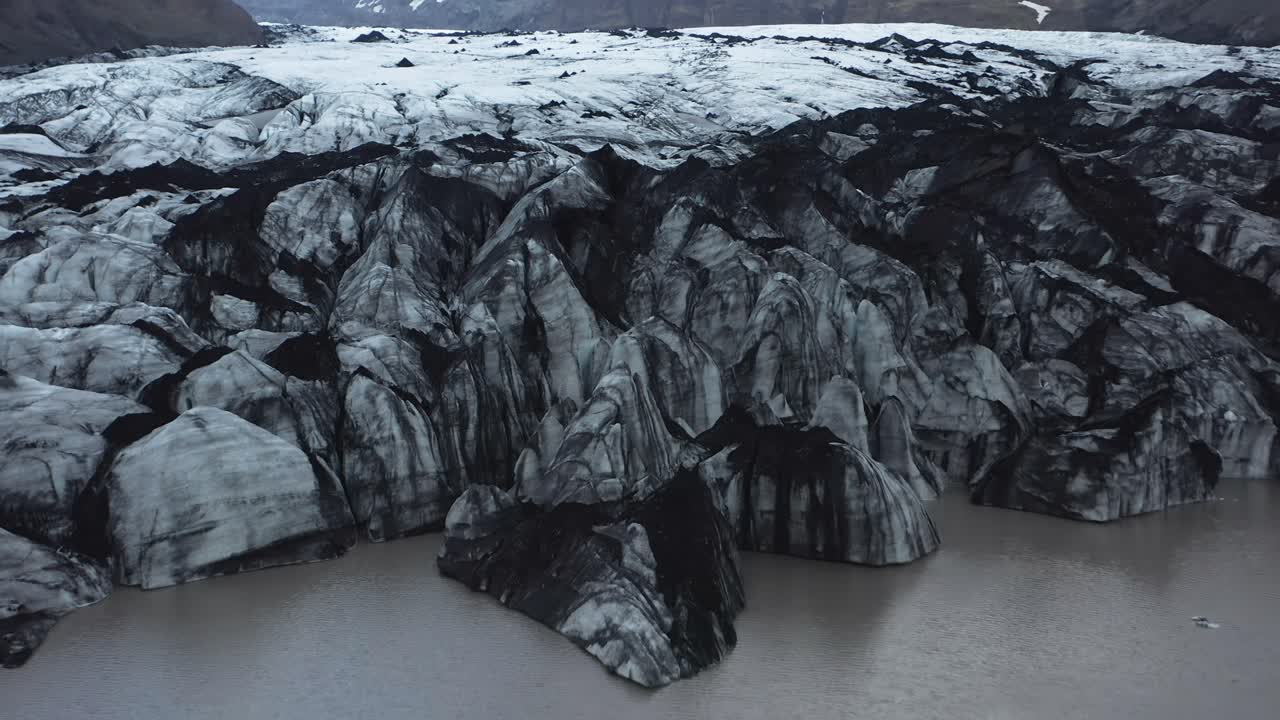 borde del glaciar en retirada en islandia cubierto de arena negra, calentamiento global