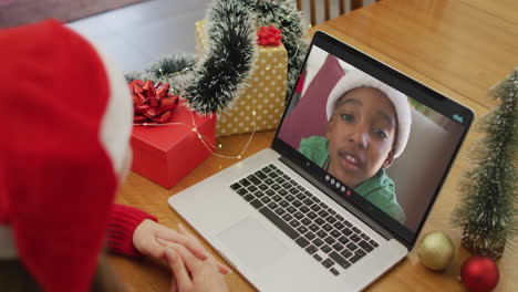 mujer caucásica en videollamada con un niño afroamericano en tiempo de navidad