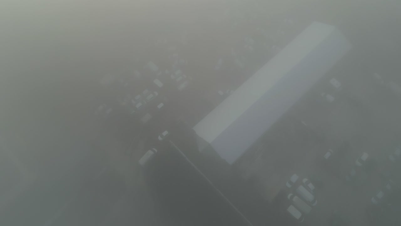 A foggy cityscape in the early morning with limited visibility, aerial view