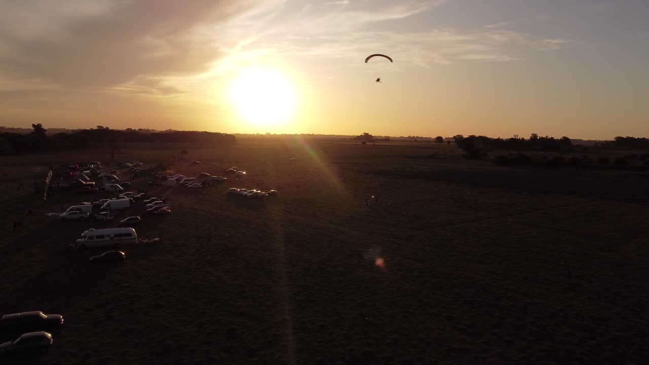 silueta de parapente paratrike motorizado volando a la luz de la llamarada solar