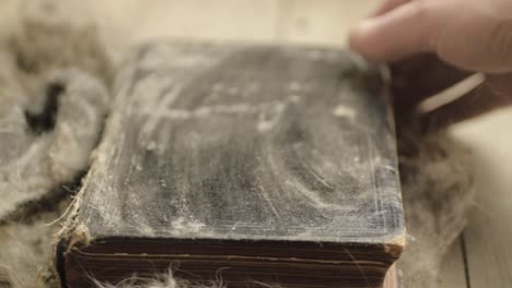 limpiar el polvo de un libro viejo y sucio para abrir páginas.