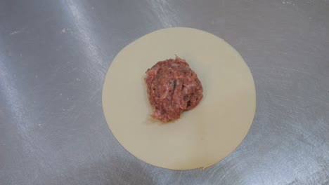 chinkali, chef adds minced meat filling onto prepared dough piece