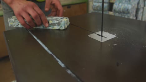 trabajador cortando un pedazo de bloque de hormigón