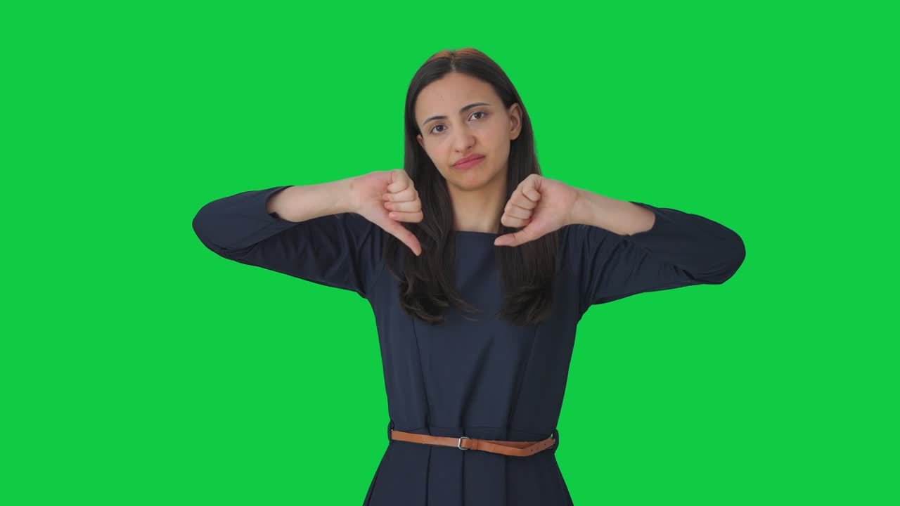 chica india molesta mostrando los pulgares hacia abajo pantalla verde