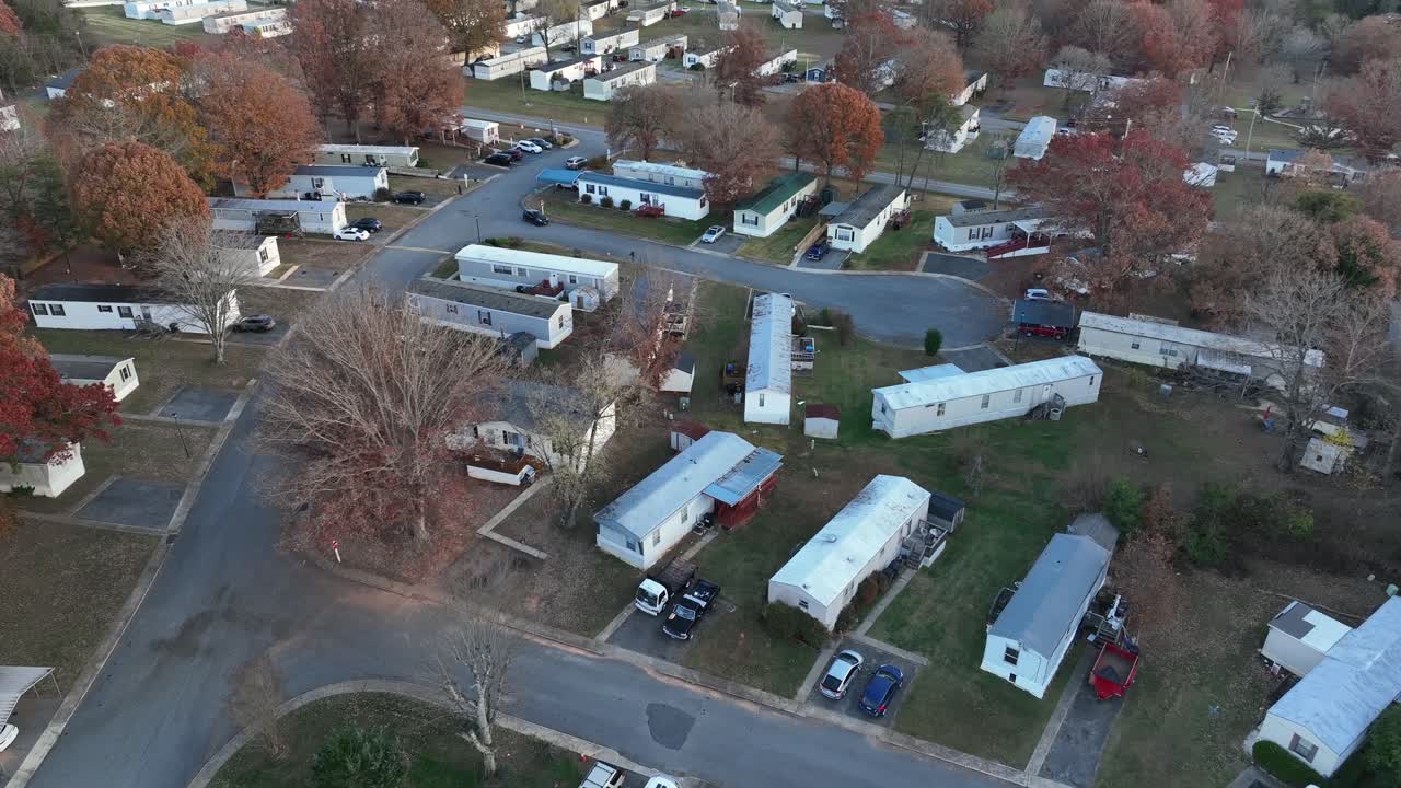 Peaceful low income housing with mobile trailer homes in idyllic suburbia of American Town. Late autumn with colored trees at sunset. Aerial view. Virginia, usa