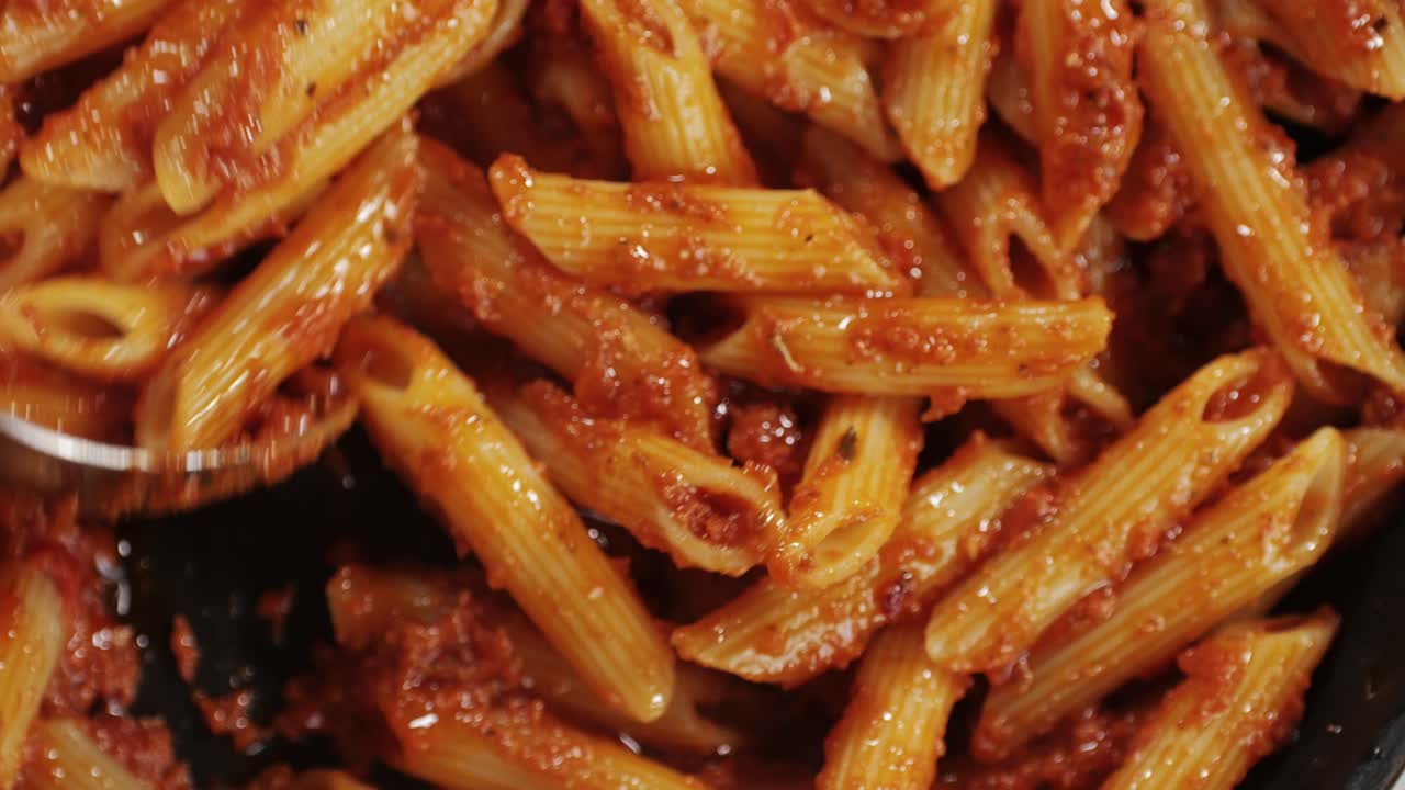 Cooking traditional arrabbiata pasta, penne with tomato sauce top view. Cook classic homemade Italian tomato sauce for pasta and pizza in the pan. Chef cooks traditional Italian food. High quality 4k footage