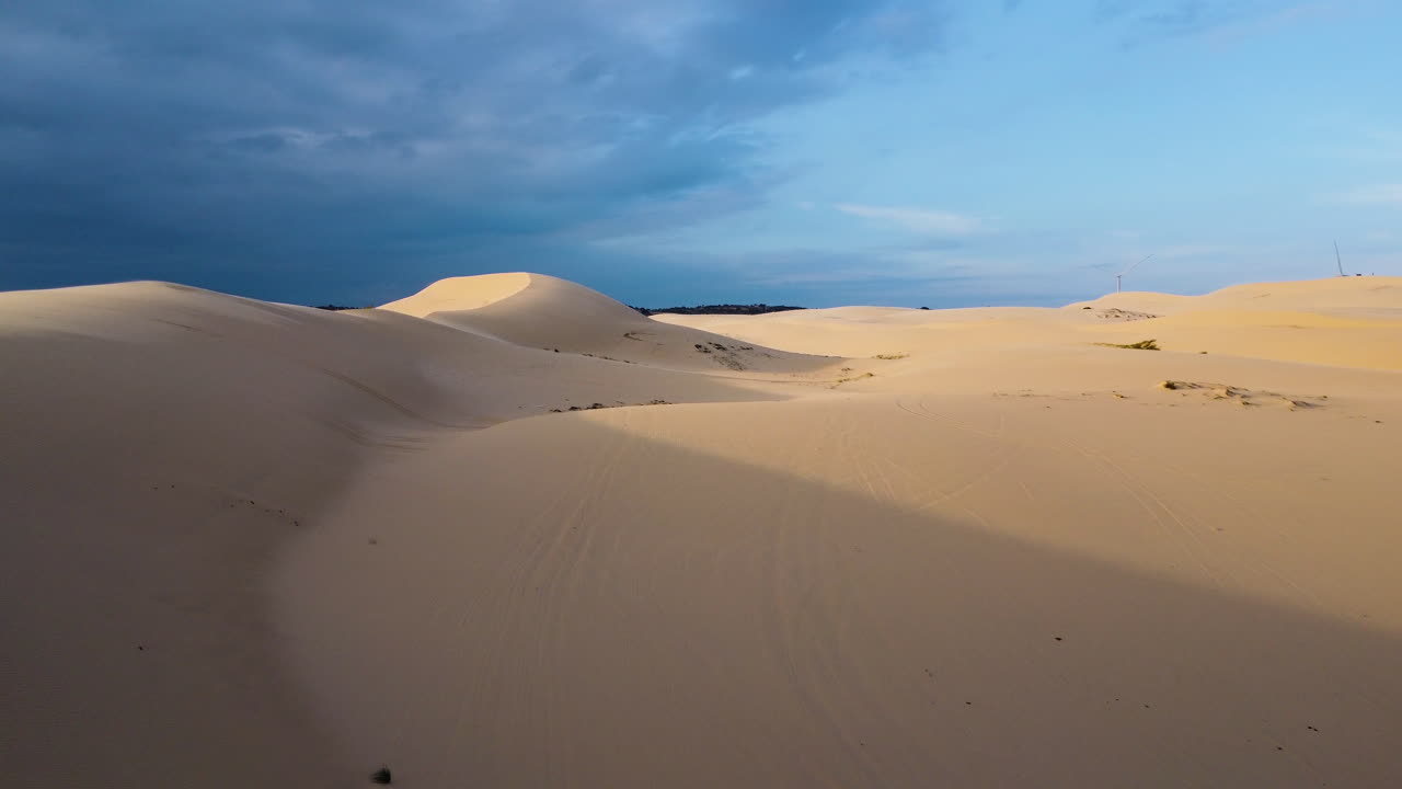 vista aérea hacia adelante de hermosas dunas blancas que se pierden en el horizonte al atardecer