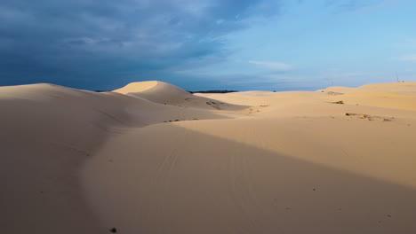 aerial forward view of beautiful white dunes losing themselves in the horizon at sunset