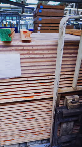 factory of laminate production. forklift truck taking a pile of wooden pallets. interior of warehouse of a parquet board production. vertical video