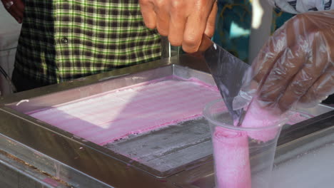 haciendo helado enrollado en frío en un puesto callejero
