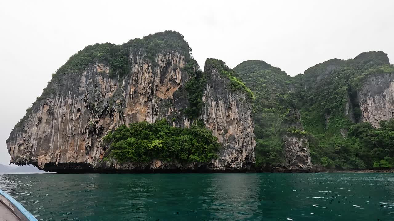el barco viaja a lo largo de la pintoresca costa de krabi.