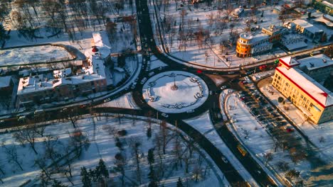 4k aerial view timelapse of roundabout road with circular cars in small european city at sunny winter day, steady shot