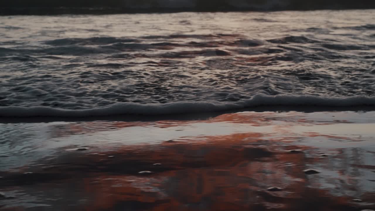 Onde che si infrangono su una superficie spumosa durante il tramonto