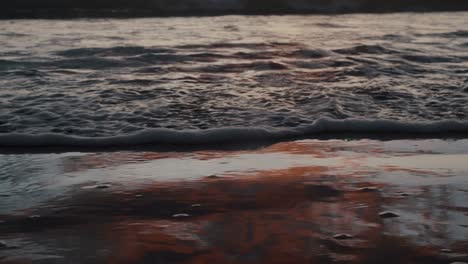 waves rolling over foamy surface during sunset