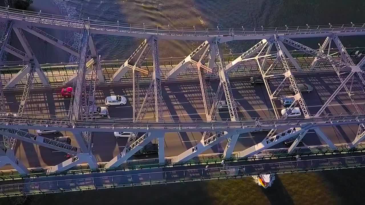 금속 다리와 지나가는 자동차의 공중 슬로우 모션 뷰를 아래로 기울이기