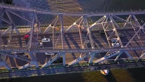 tilting down aerial slow motion view of a metal bridge and passing cars